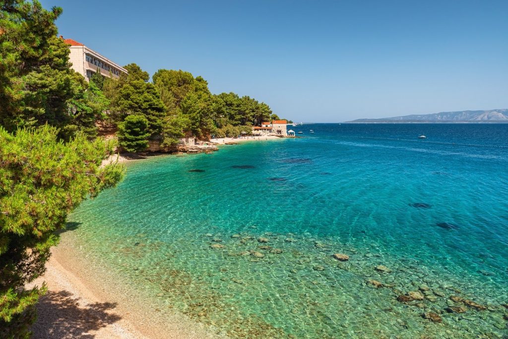 Croatia, Brac island, Bol. Beautiful view of pebble beach on Adriatic sea with small restaurant