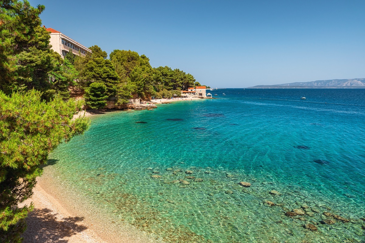 Croatia, Brac island, Bol. Beautiful view of pebble beach on Adriatic sea with small restaurant