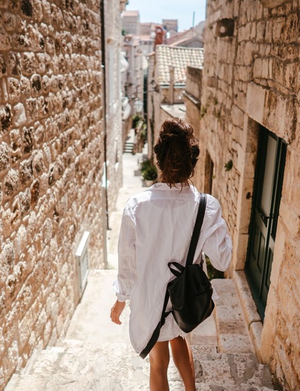 Young girl walking through ancient narrow streets on a beautiful summer day